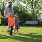 A joyful family with children strolling in a sunny Portuguese park.